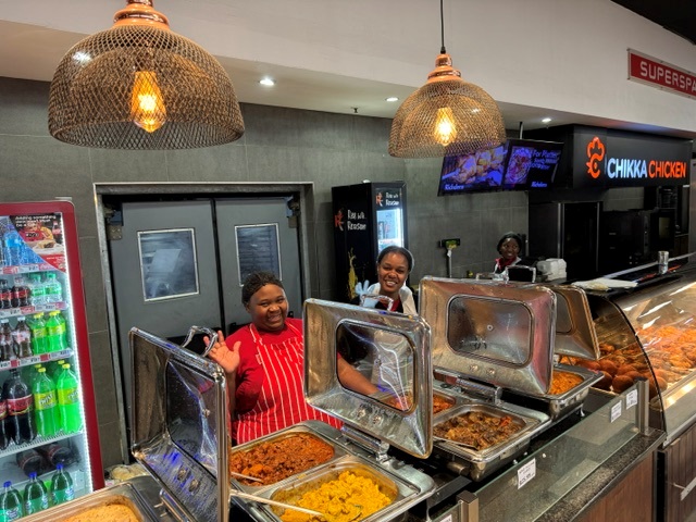 Staff serving hot food at the Chikka Chicken counter